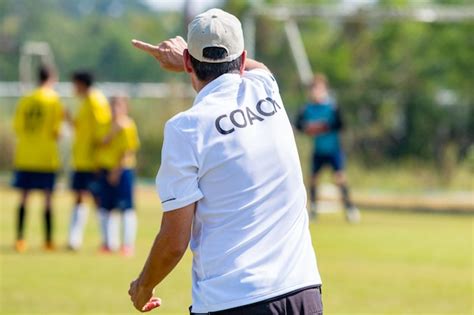 Detrás del entrenador de fútbol vistiendo camisa blanca de entrenador