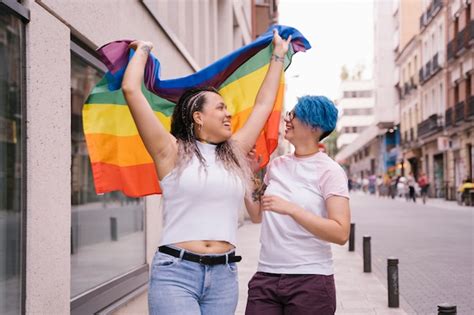 Premium Photo Lesbian Couple With Playful Attitude Showing Proudly A Pride Lgbt Flag