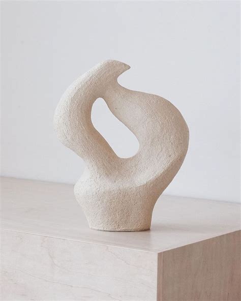 A White Sculpture Sitting On Top Of A Wooden Block