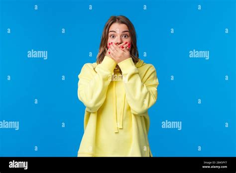 Schockiert und sprachlos beeindruckte blonde Frau den Mund mit Händen und Stare überraschte