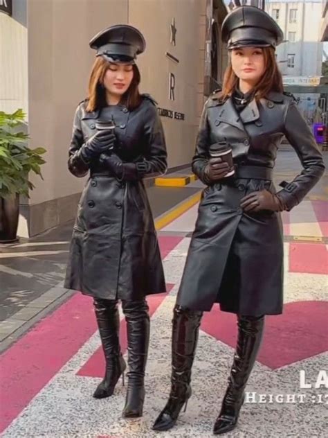 Two Women Dressed In Black Standing Next To Each Other On The Sidewalk With Their Hands Together