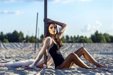 Attractive Brunette Woman In Black Body And Translucent Beach Cover Up Posing On Sandy Beach At