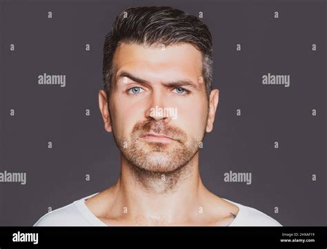 Closeup Portrait Of Handsome Shaved Man With Bristle And Eyebrow Raised