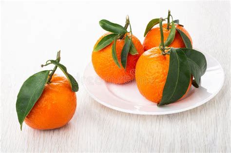 Tres Mandarinas Con Las Hojas En Placa Y Mandarina En La Tabla Foto De