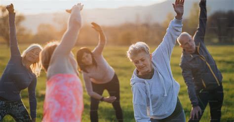 A group of seniors with sport instructor doing exercise outdoors in ...