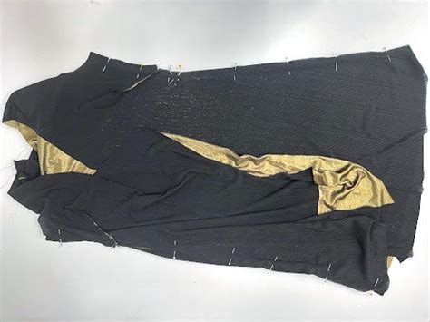 An Old Piece Of Cloth With Gold Thread On The Side And Black Fabric At