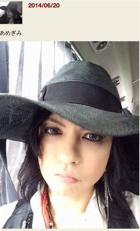 A Woman Wearing A Black Hat In The Back Seat Of A Car Looking At The Camera