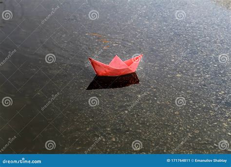 Origami Ship Or Paper Boat Sails In A Puddle Formed After Rain Rainy