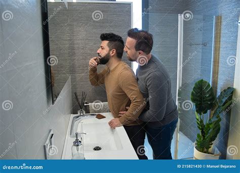 Gay Married Hugging In The Bathroom Of Their Home While Combing Their Hair Very Affectionate