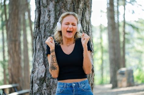 Une Fille Blonde Crie Et L Ve Les Poings Tout En Coutant De La Musique Sur Un Casque Sur Fond