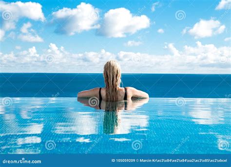 Beautiful Blonde Woman Model With Long Wet Hair And Elegant Makeup Lies In A Pool Stock Image