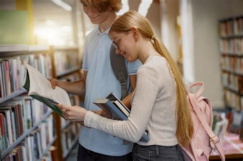 Premium Photo | Two friends student chooses books while standing in the ...