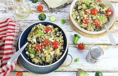 Two Bowls Filled With Food Sitting On Top Of A Wooden Table Next To