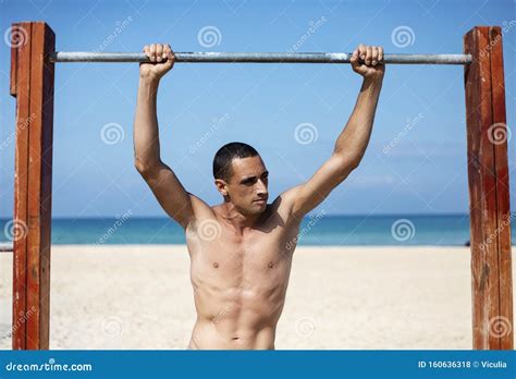 A Male Athlete With A Naked Torso Is Training On A Horizontal Bar Stock Photo Image Of Body