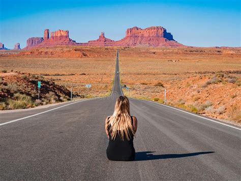 Une Jeune Fille Blonde Assise Au Centre De Forrest Gump Point Road Monument Valley Image Stock