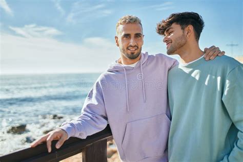 Jovem Casal Gay Sorrindo Feliz E Abraçando Na Praia Foto de Stock Imagem de adulto amor