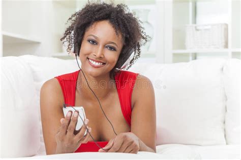 Menina Afro Americano Que Escuta Fones De Ouvido Do Leitor De Mp3 Foto