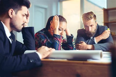 Frustrated Business People Sitting At The Table In Office Arguing