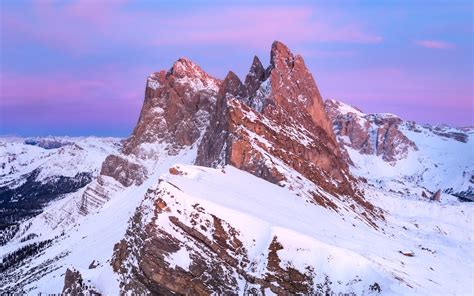 A mountain range covered in snow under a purple sky photo – Free Seceda ...