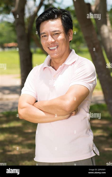 Portrait Of Happy Mature Vietnamese Man Smiling At Camera Stock Photo