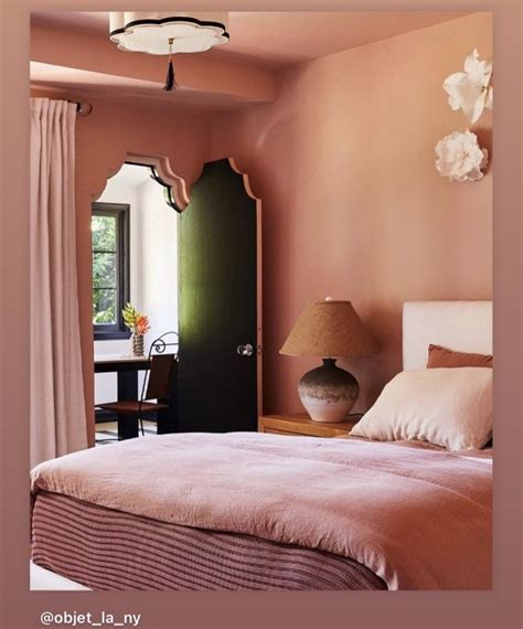 A Bedroom With Pink Walls And White Bedding In Front Of A Doorway That