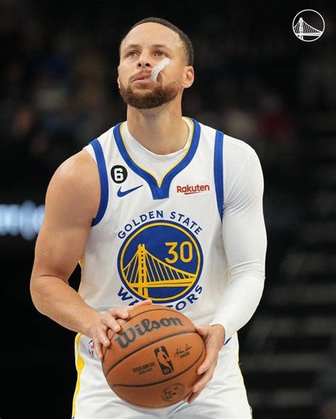 a man holding a basketball in his right hand and looking up at the sky ...