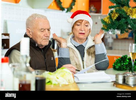 Mature Couple Sitting With Financial Documents Before Christmas Dinner Stock Photo Alamy