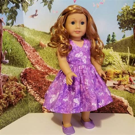 The Doll Is Wearing A Purple Dress And Shoes