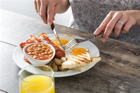 Premium Photo | Woman eating a traditional english breakfast with fried ...
