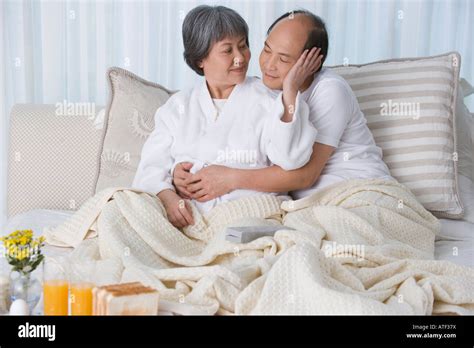 Mature Couple Embracing Each Other On The Bed Stock Photo Alamy