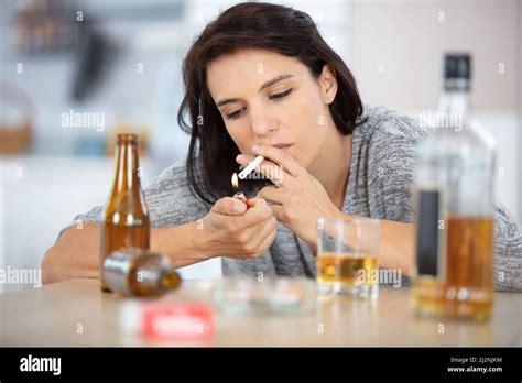 woman holding a cigarette smoking and drinking alcohol Stock Photo - Alamy