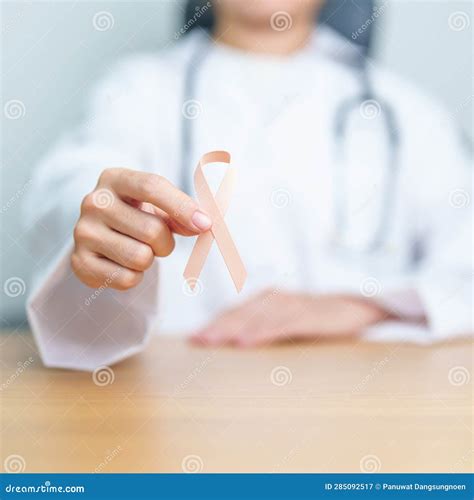 Doctor Holding Peach Ribbon For September Uterine Cancer Awareness