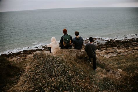 Boys Sitting on a Rock Overlooking the Beach · Free Stock Photo