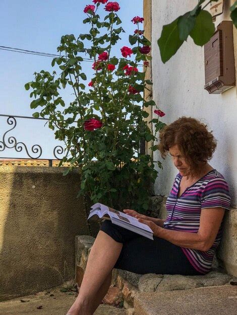 Premium Photo Woman Reading Book While Sitting Against Tree