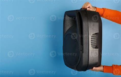 Man holds a big sound box to listen music. blue background 20623094 ...