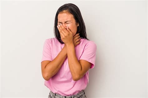 Joven latina aislada sobre fondo blanco sufre dolor de garganta debido a un virus o infección