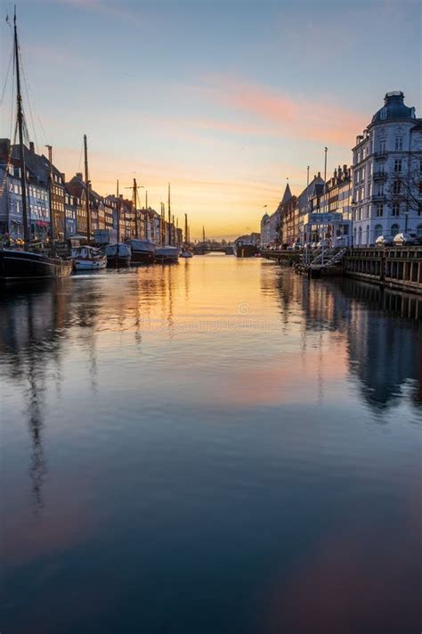 Buildings And Boats In Nyhavn Against Scenic Sunrise Editorial Stock