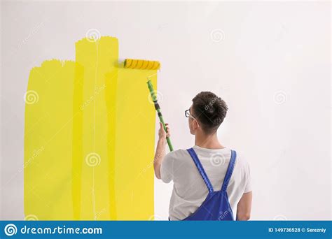 Pared Masculina De La Pintura Del Decorador Con El Rodillo Dentro Foto