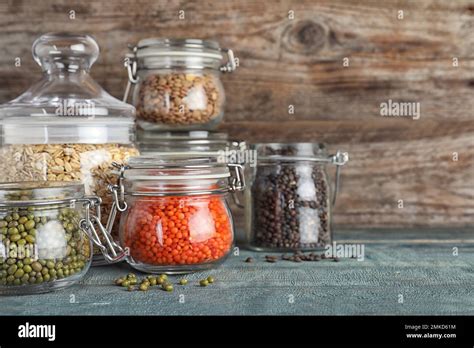 Different Types Of Legumes And Cereals In Glass Jars On Blue Wooden