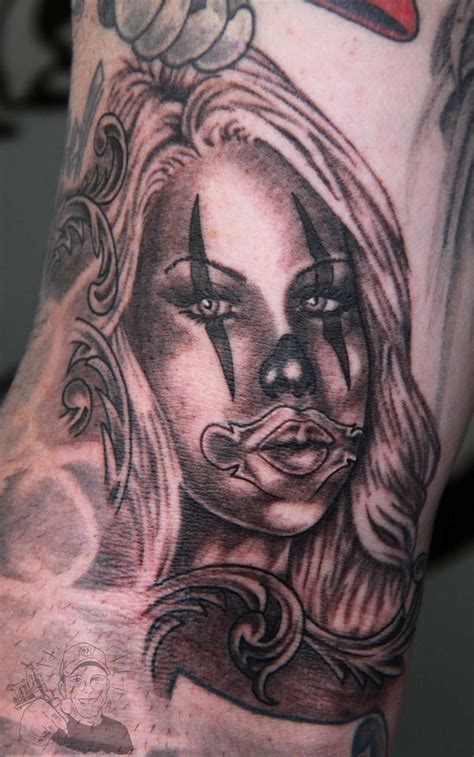 a close up of a person's arm with a clown face tattoo on it