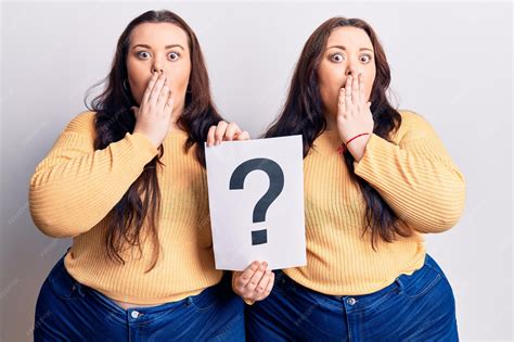 Premium Photo | Young plus size twins holding question mark covering ...