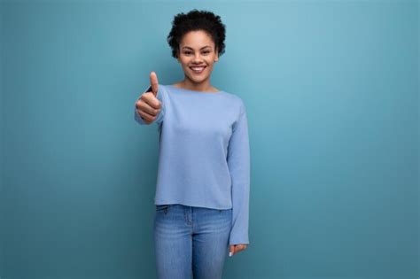 Premium Photo Confident Pretty Brunette Lady With Afro Curls Showing Super Hand Gesture On