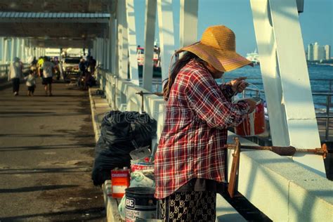 A Mature Thai Woman With A Big Hat Was Painting The Structure Of The