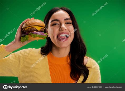 Brunette Woman Holding Tasty Burger Sticking Out Tongue Isolated Green Stock Photo
