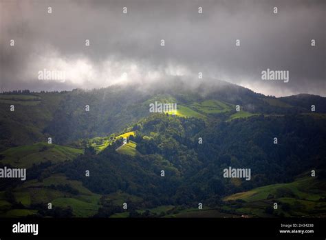 Bright Sunlight Shining Through Hole Of Clouds To Dark Scene Of