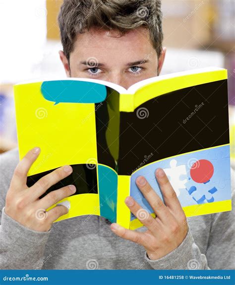 Allievo Maschio Che Nasconde Il Suo Fronte Dietro Un Libro Fotografia