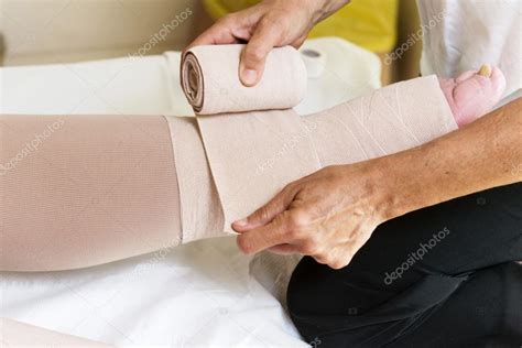 Woman Bandaging Patients Legs Stock Photo By ©vpardi 113161298