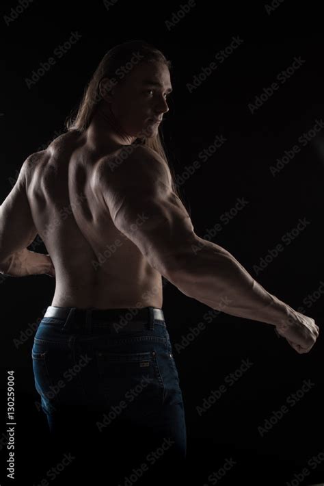 Naked Torso Male Bodybuilder Athlete With Long Blond Hair In Studio On A Black Background Stock