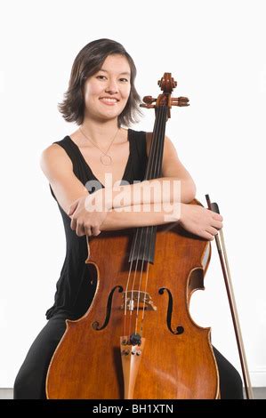 Nude Woman Sitting With Arms Folded Across Chest Covering Mouth With Strand Of Hair Stock Photo