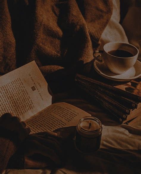 A Cup Of Coffee And Some Books On A Bed Next To A Blanket With A Candle